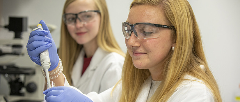 two female students work in a biomed lab