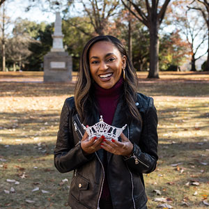 Jada Samuel smiles and holds her crown on the USC Horseshoe